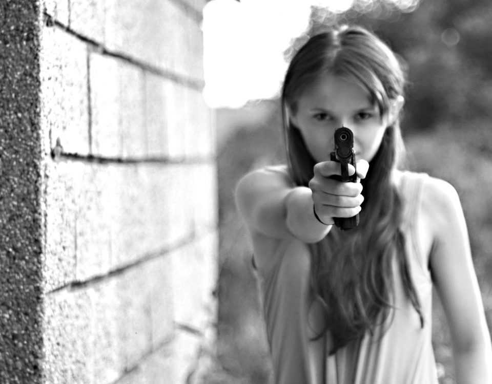 Adolescente apontando a arma.