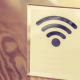 Símbolo de WiFi em placa de acrílico sobre a mesa.